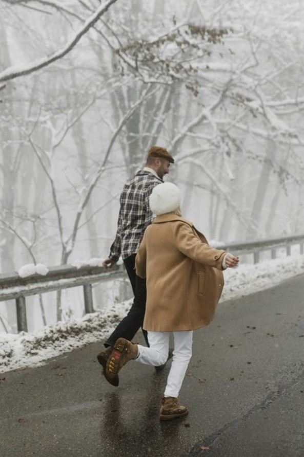 2 people walking on side of street in winter