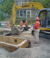 Sewer District workers using an excavator